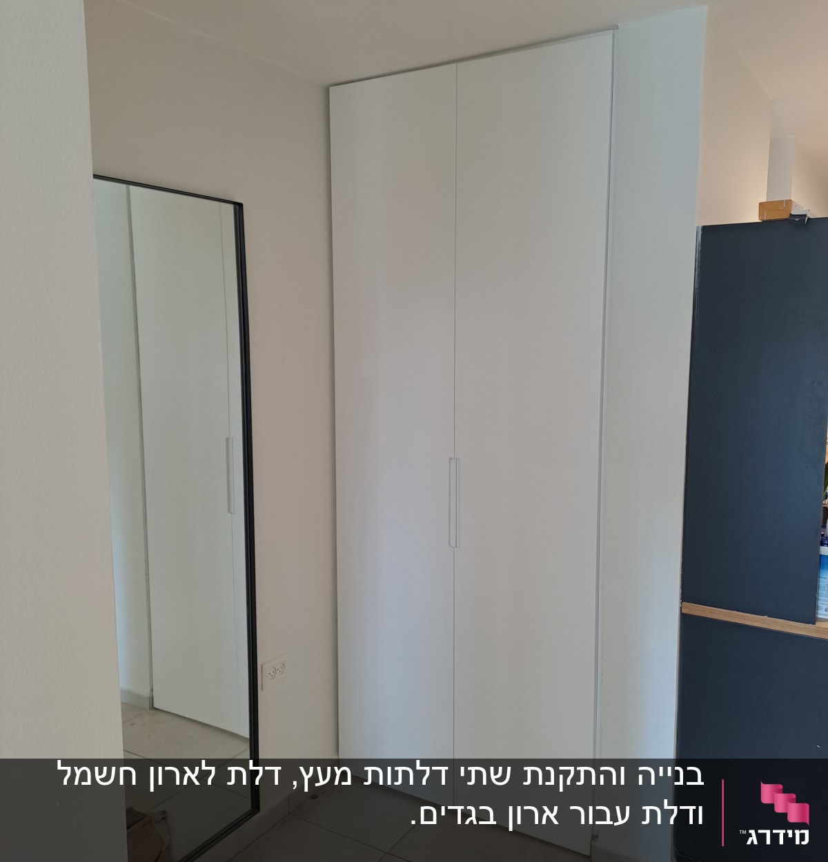 ארון לבן עם דלתות סגורות ליד מראה